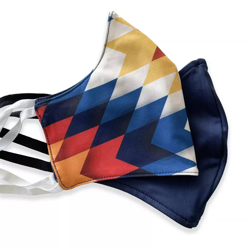 Colorful geometric and solid navy face masks lying side by side