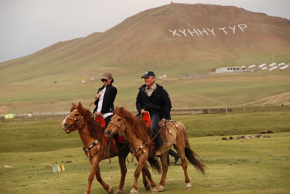 Man and woman horseback riding in Mongolia