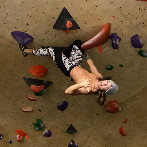 rock climber hanging upside down wearing white black meggings