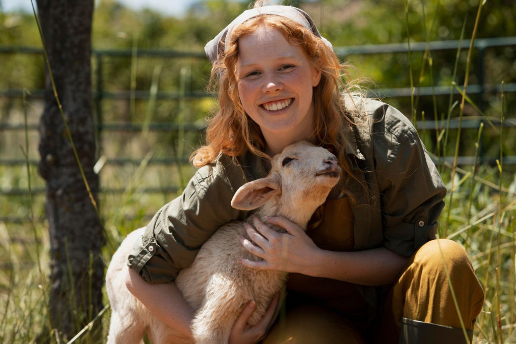 rothaarige Frau mit kleinem Lamm in der Natur