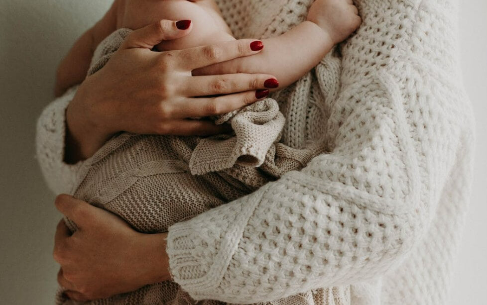 woman holding newborn after birth