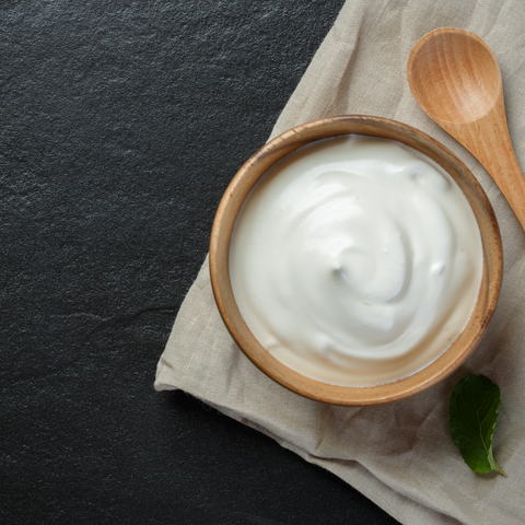 a wooden bowl with plain yogurt in it