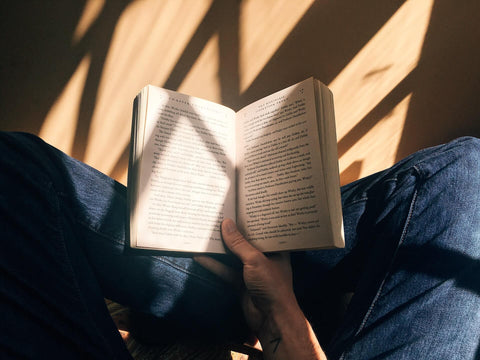 Person reading a book in the sunlight. 