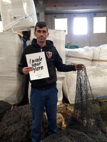 Sanel holds a poster which reads "I made your yarn"