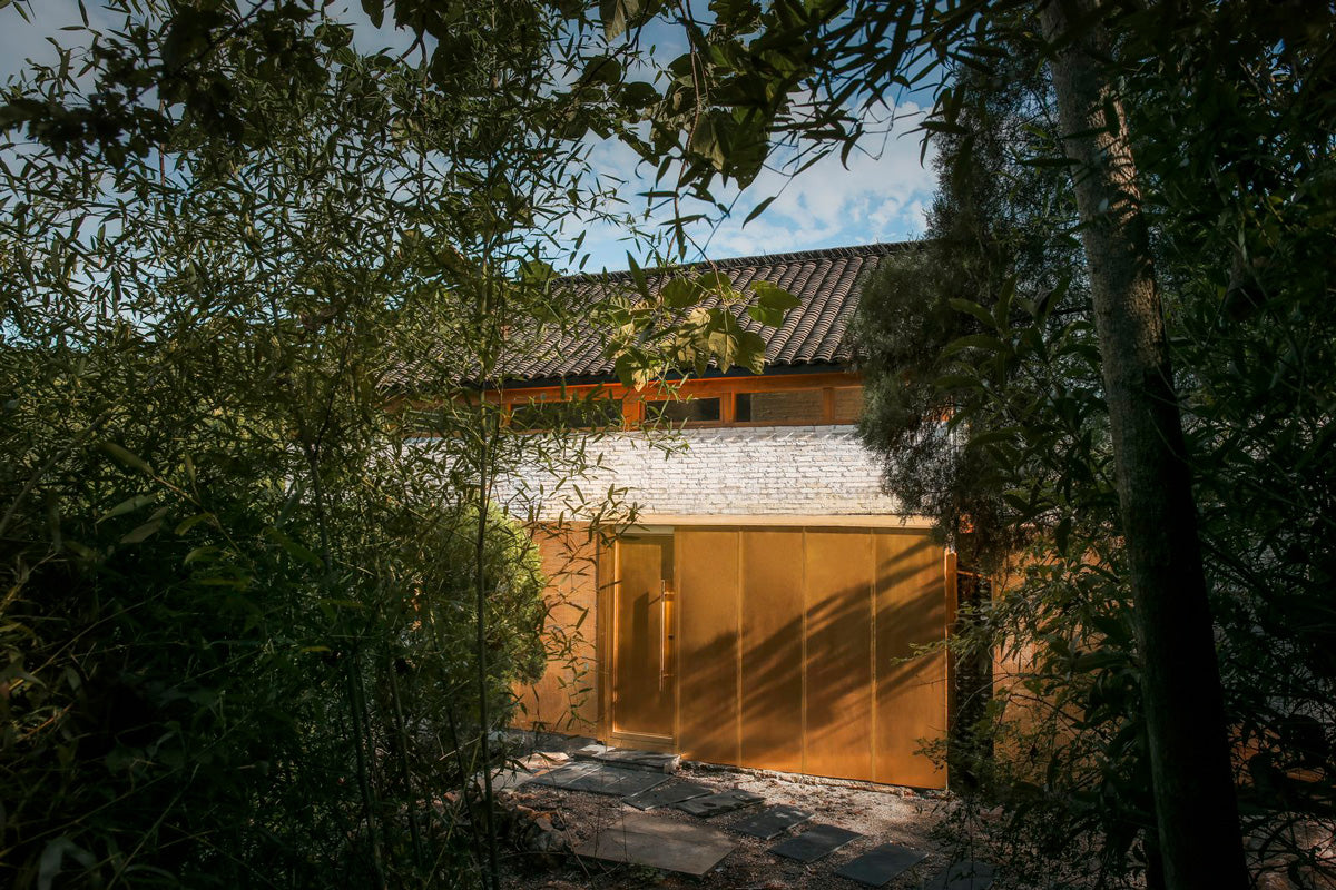 El cobre es un elemento que unifica la casa. Dentro, está presente en las escaleras, la puerta, la cocina, en el marco del comedor, mientras aparece también fuera, en la terraza y los aleros.