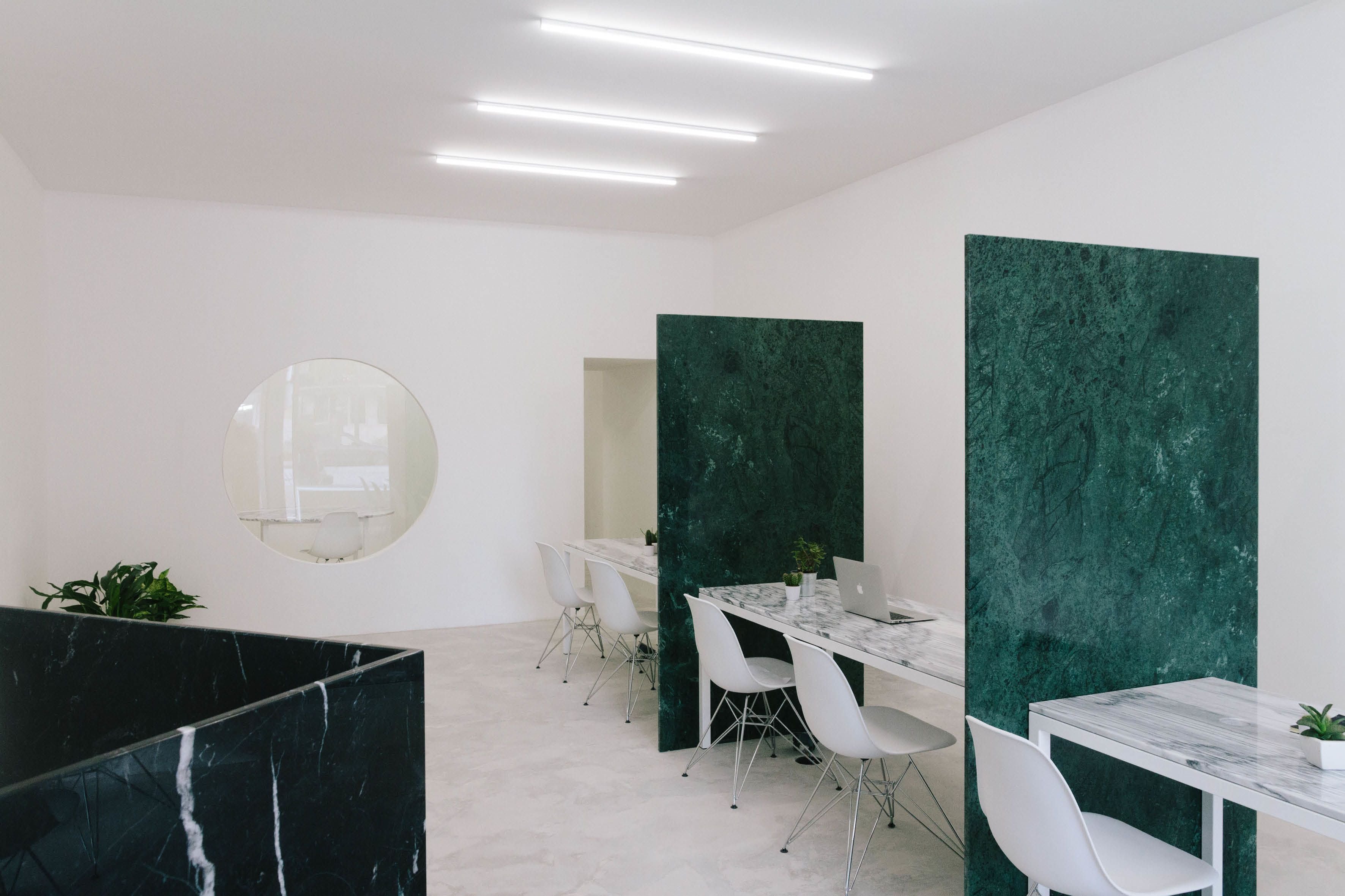 Fala Atelier transformó lo que era una tienda de ropa en Oporto en una agencia inmobiliaria repleta de mármol. Utilizó diferentes colores como el verde para las divisiones de espacios de trabajo, gris para las mesas y negro para la recepción.