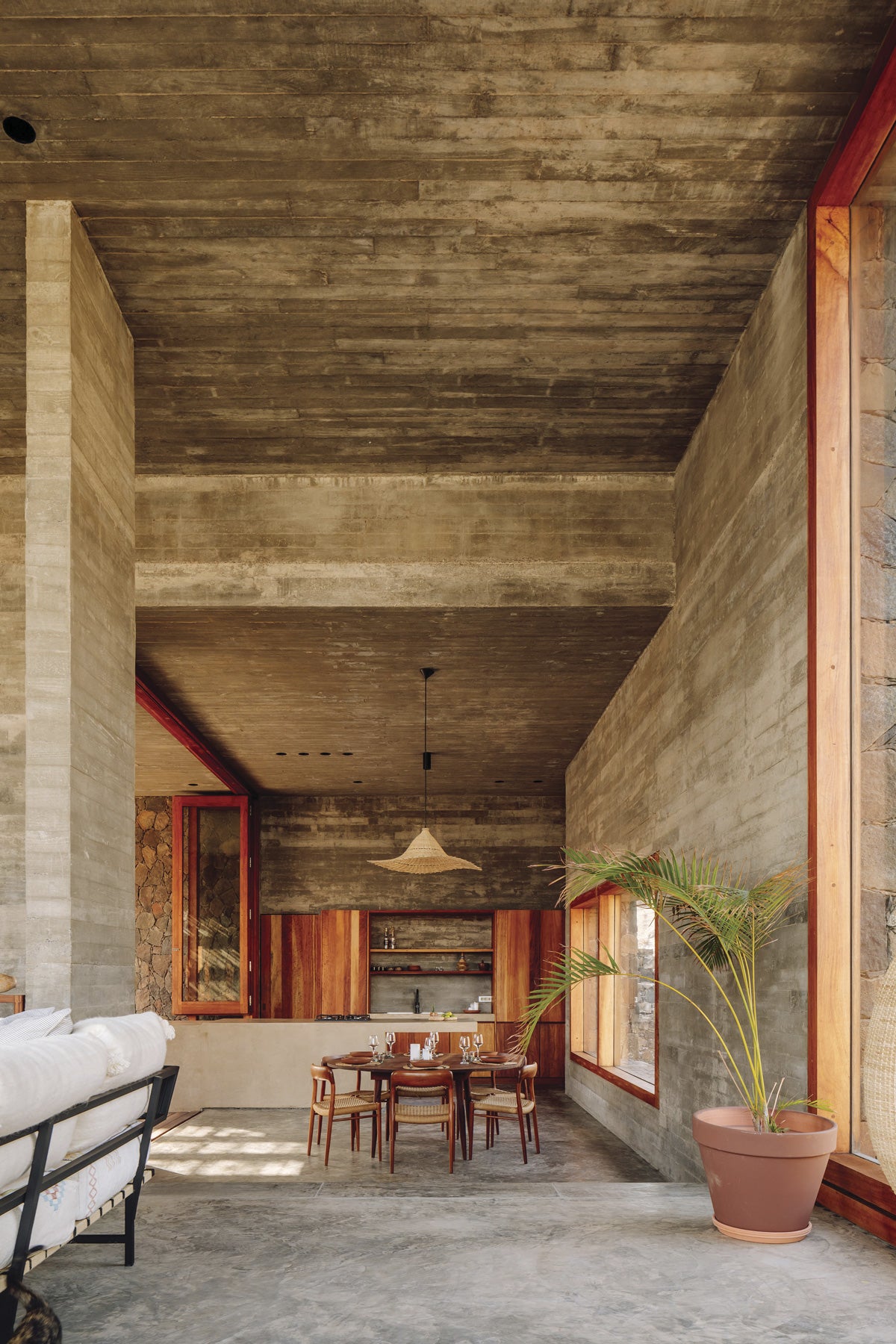 The design studio has added a selection of furniture in natural hues to the interior decoration of the villas, featuring concrete surfaces and planks. The wood, also in warm tones, is used for making cabinets and window frames. The high pergolas are finished with rattan strips, which offer shade to the deck chairs.