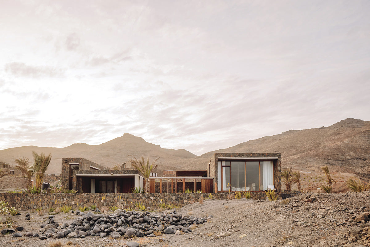 Polo Architects and Going East have matched cobblestone walls with neutral interiors to camouflage the complex against the rocky land of the island. 