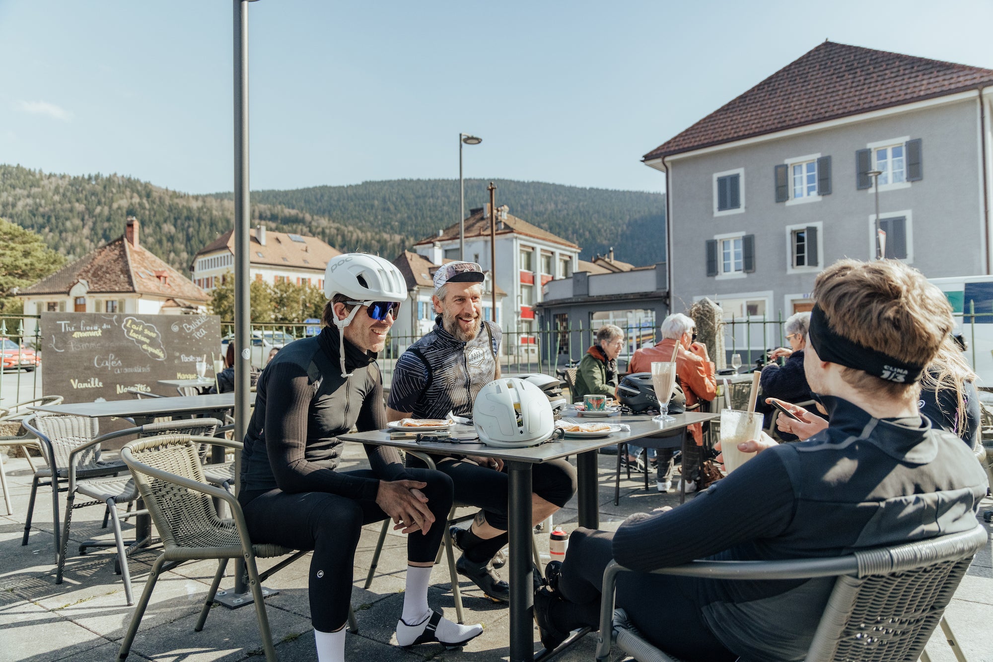 Cyclists talking during a coffee stop whilst riding in Switzerland