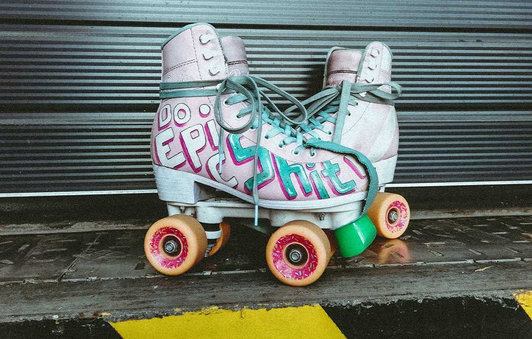 Roller skates pink with graffiti on them 