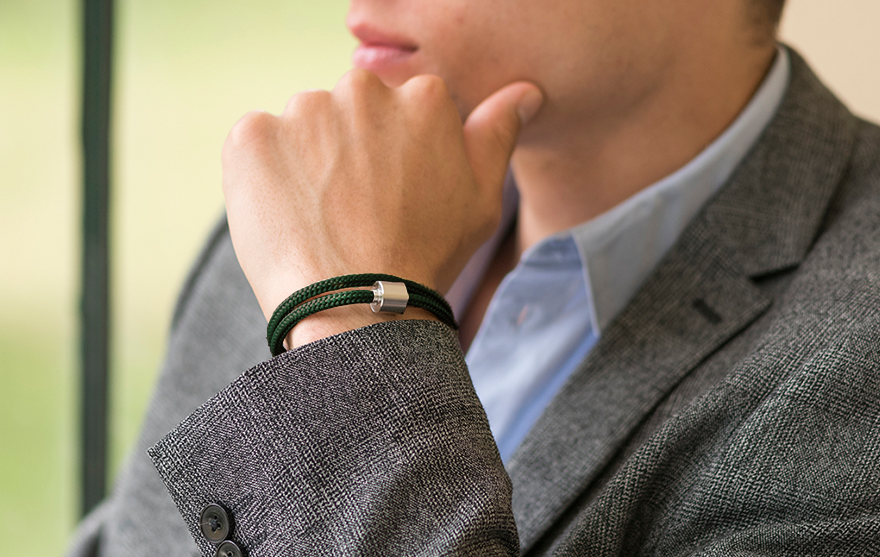 Person in grey blazer with Men’s cremation bracelet