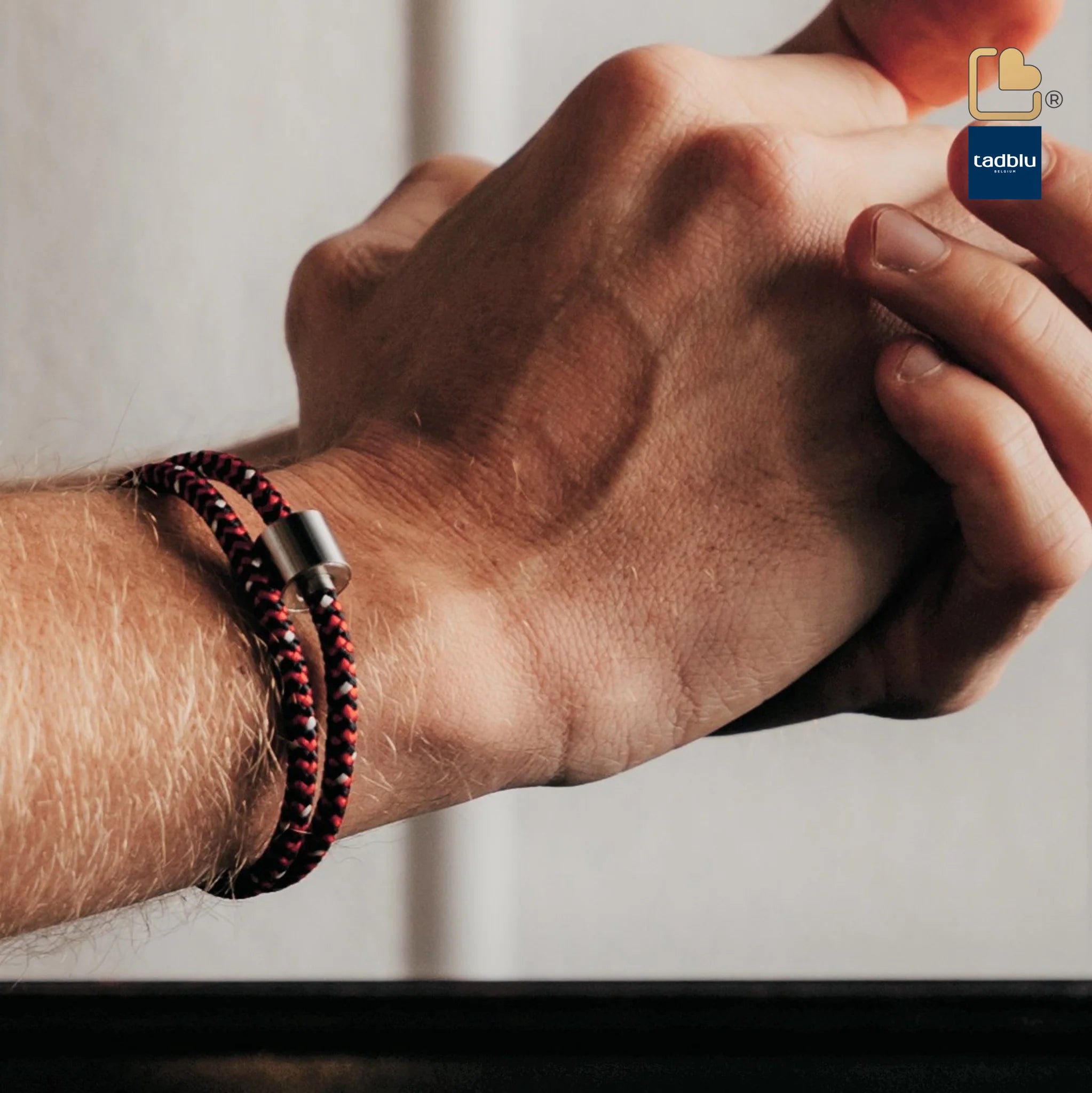 A person wearing cremation bracelet while holding his hand with someone