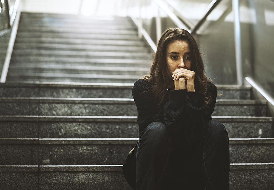 Woman looking worried while sitting on steps