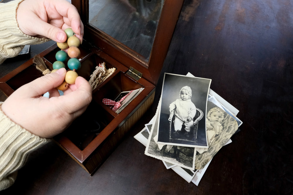 female hands sorting loved one's things from a keepsake box