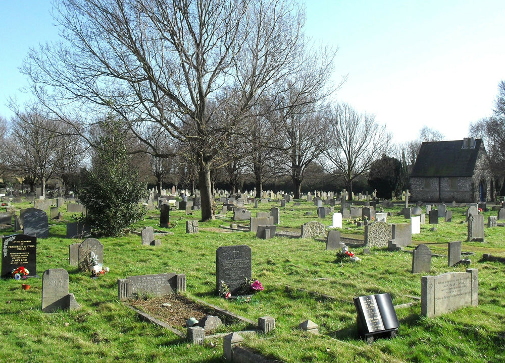 A cemetery with bright green grass and headstones.
