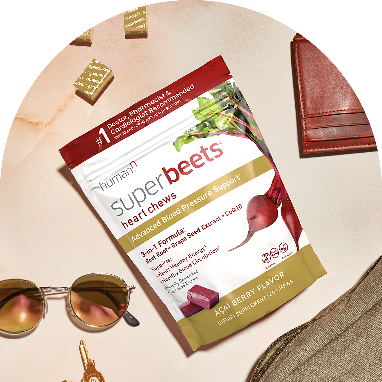 Superbeets Heart Chews Advanced package with gold wrapped chews. Sunglasses and a leather wallet are on either side.