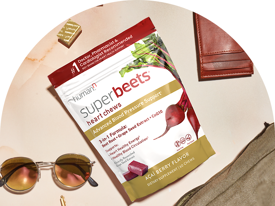 Superbeets Heart Chews Advanced package with gold wrapped chews. Sunglasses and a leather wallet are on either side.