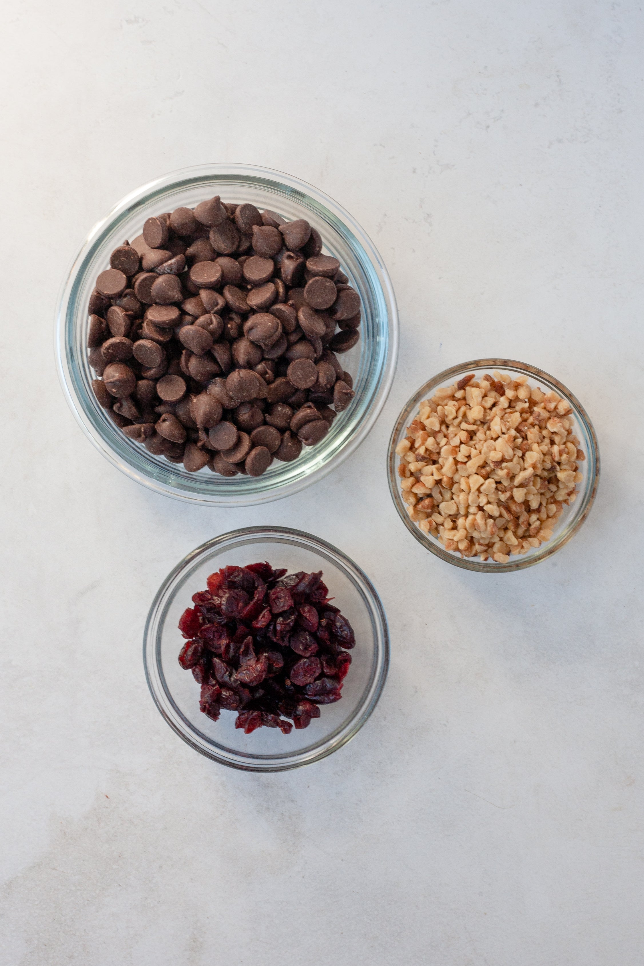 bowls of chocolate chips, dried cherries and walnuts