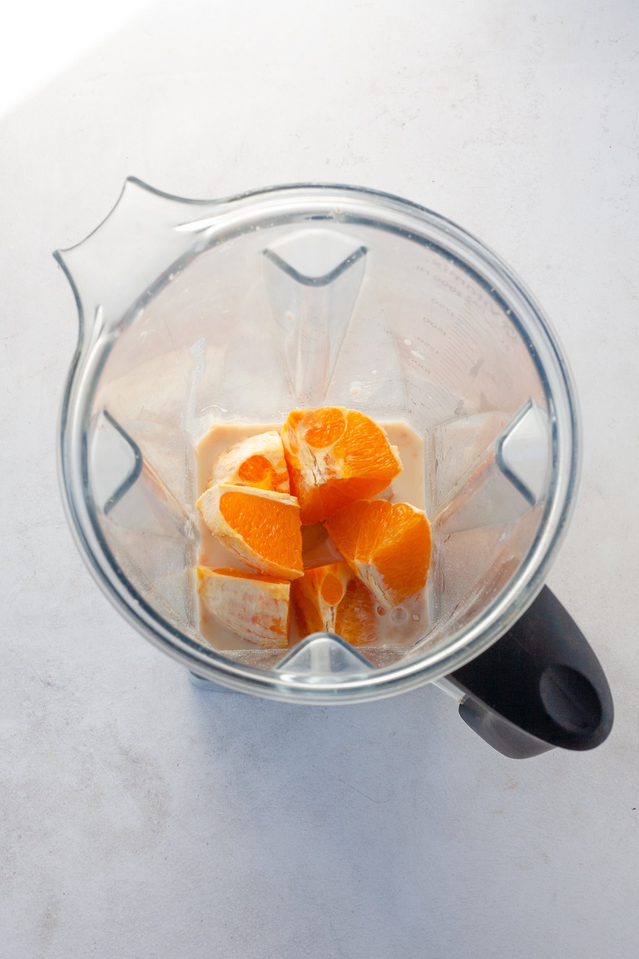 Image of orange segments in a blender with ice