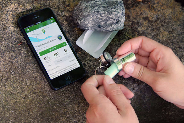 Geocaching in woods while finding cache with phone