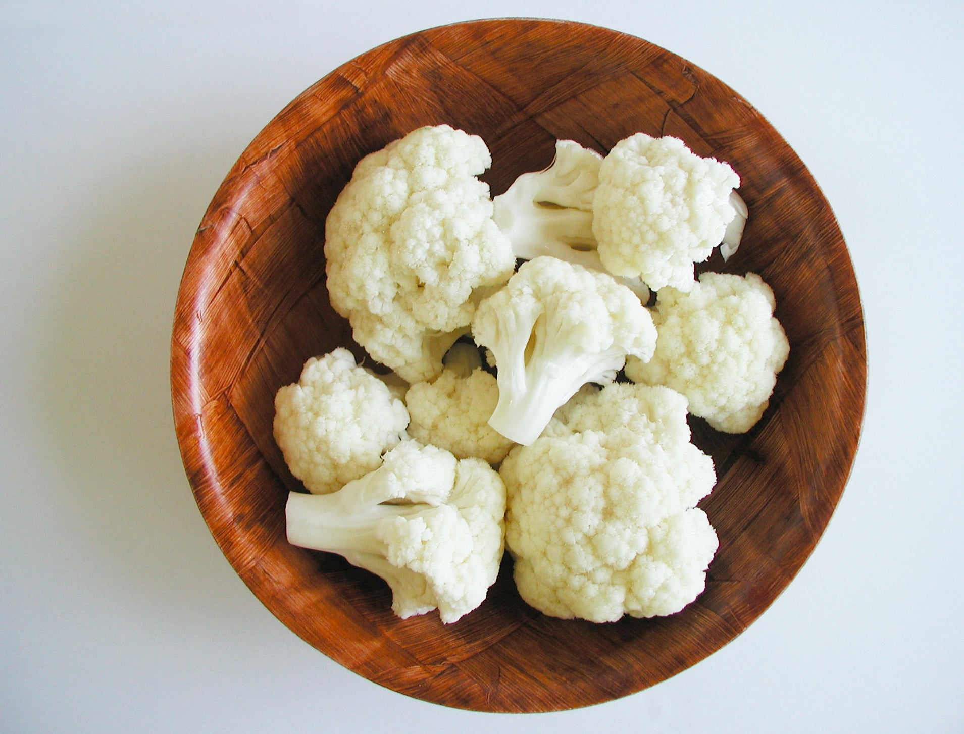 A wooden bowl of cauliflower for guinea pigs to eat