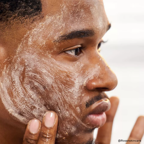 black man exfoliating his face