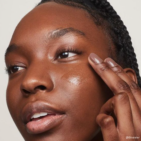 Black woman putting on skin care