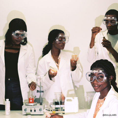 Black women in a cosmetic chemist lab