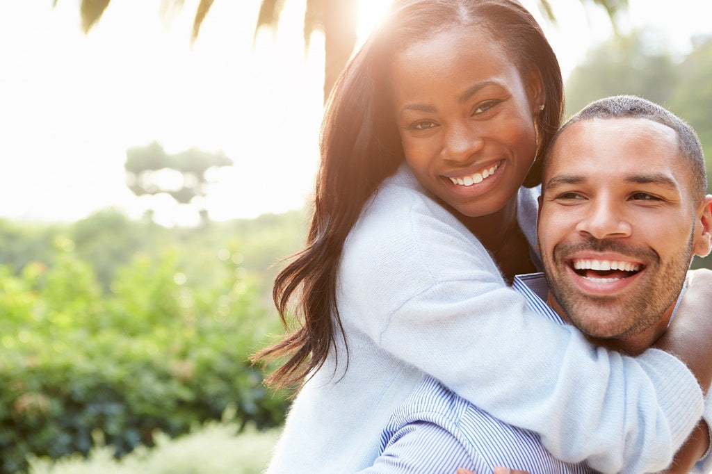 Feliz pareja comprometida con anillos de diamantes simulados