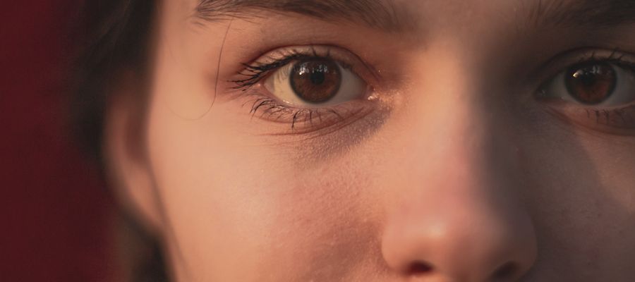 closeup of woman's face with brown eyes and right eye in the shadows