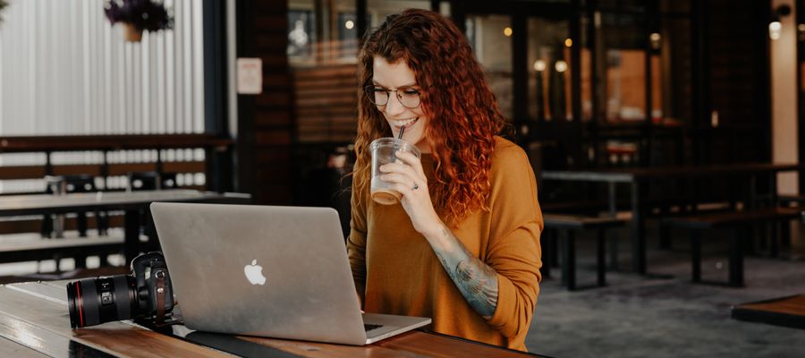 Mujer joven con anteojos trabajando en una computadora