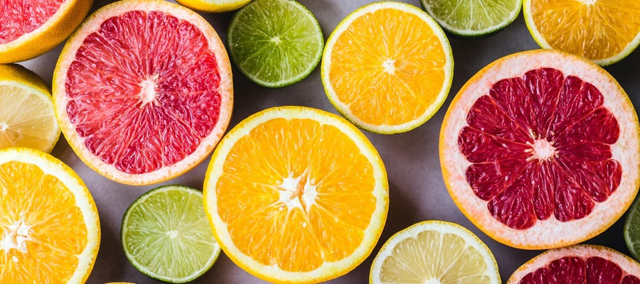 sliced citrus fruits seen from above including oranges, grapefruit, lemons, and limes