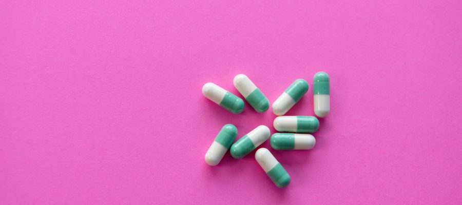 medicine capsules on pink background