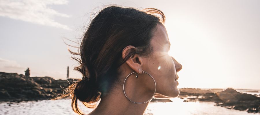 mujer con la cabeza vuelta hacia el sol