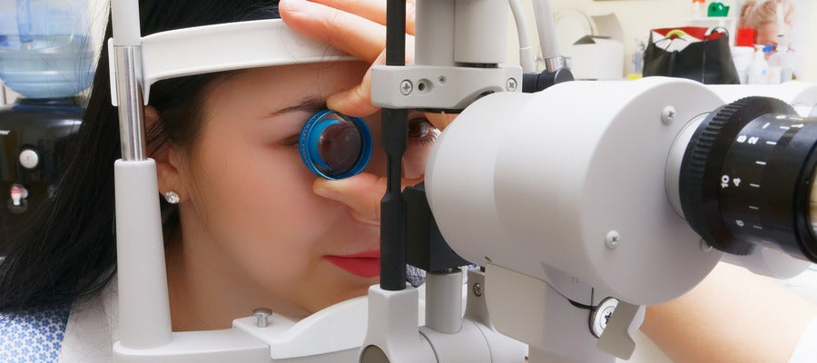 woman with dark hair undergoing eye checkup