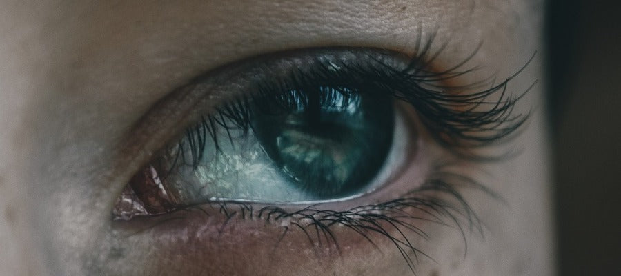 Primer plano del ojo humano verde mirando hacia un lado