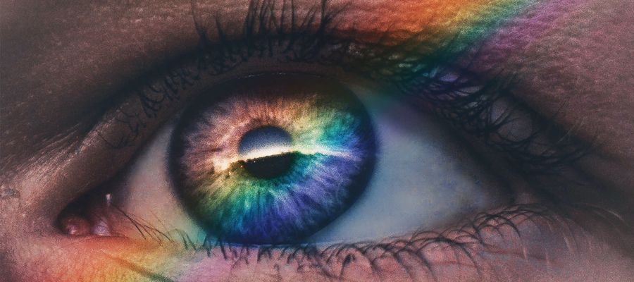 human eye with rainbow painting over it