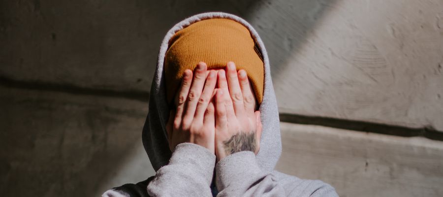 man covering face with both hands