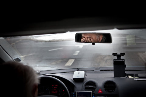 man rubbing dry eyes when driving