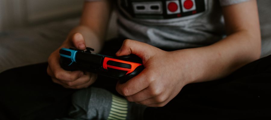 manos de un niño sosteniendo un joystick