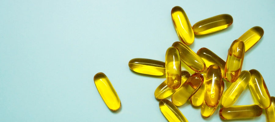 fish oil capsules scattered on lightly colored background