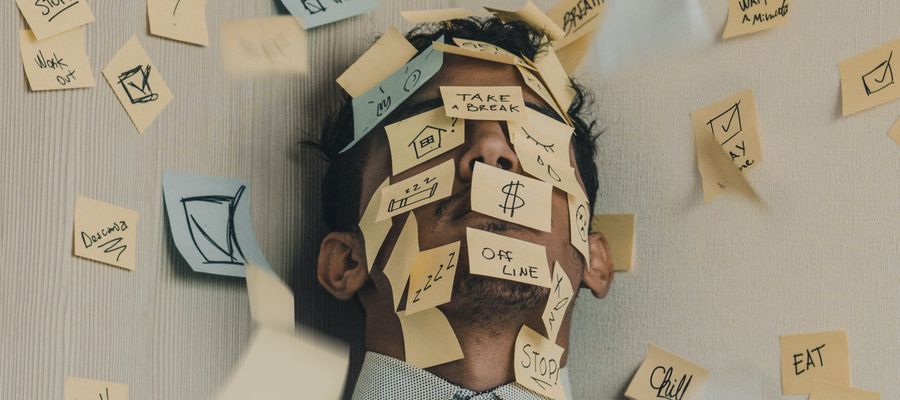 man with sticky notes on his face overwhelmed by tasks