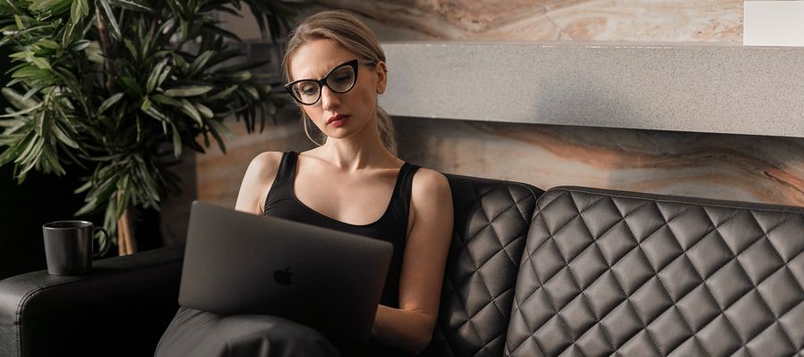 Mujer con anteojos cansada ante la computadora.