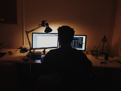 man working on his computer at night