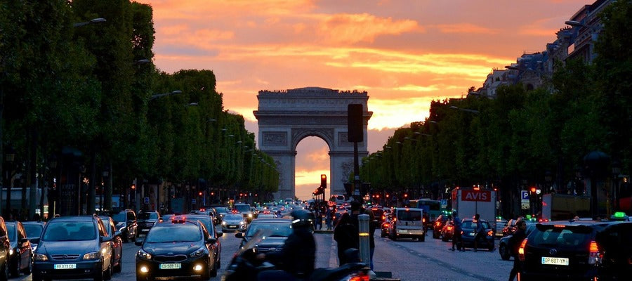 boulevard full of cars with triumphal arch in the background