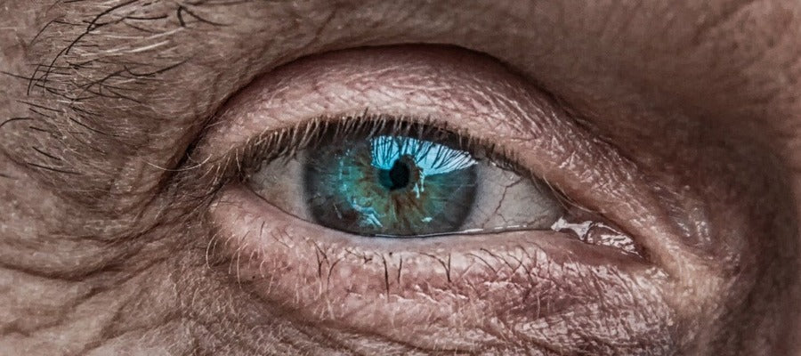 closeup of old human eye surrounded by wrinkles