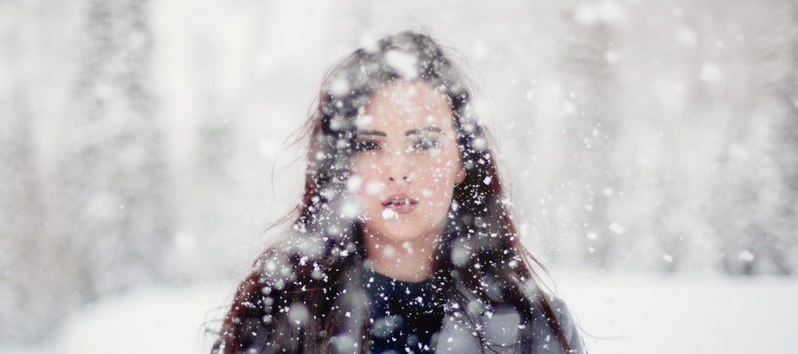 young woman standing in light snow storm