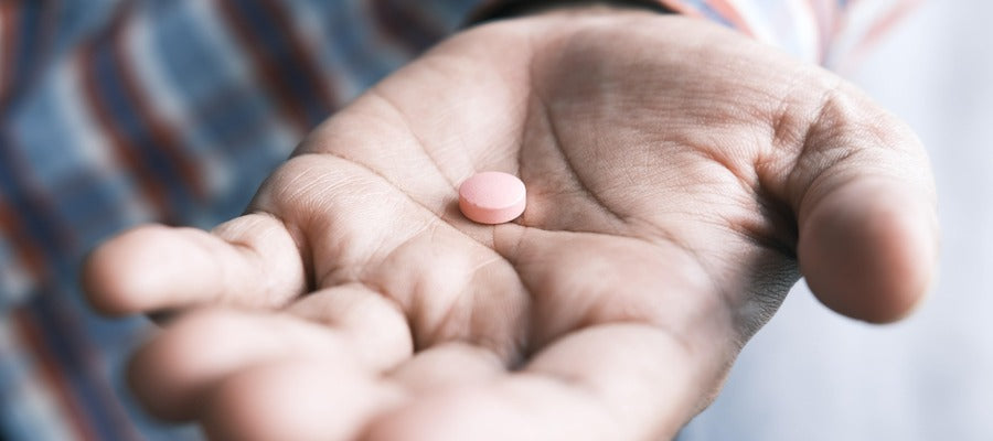 palma masculina sosteniendo pastilla rosa