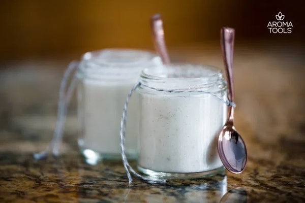 Two 4 ounce glass jars with miniature spoons filled with essential-oil flavored sugar.