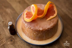 Our Pink Grapefruit Yogurt Cake featuring grapefruit essential oil on a small plate drizzled with a glaze and topped with a grapefruit swirl. 